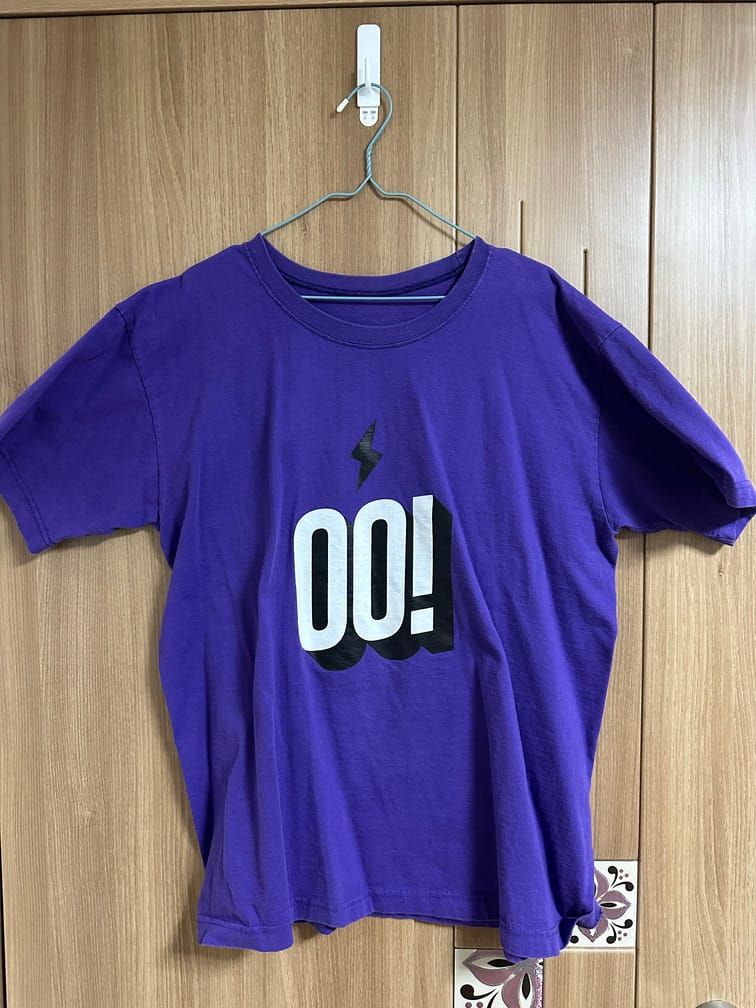 남색 반팔 티셔츠의 앞면에 OO! 라는 흰 글자와 검은 번개 마크가 그려져 있다.