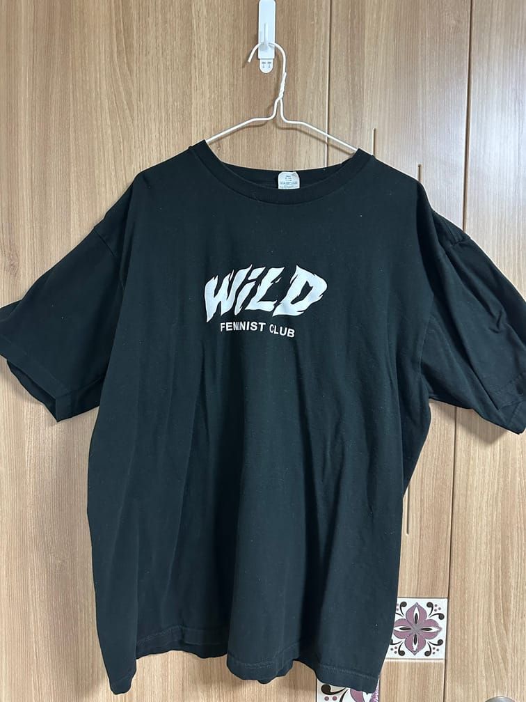 검은 티셔츠에 WiLD라는 크고 힘찬 흰 글씨 아래, FEMINIST CLUB이라는 굵은 산세리프체 흰 글씨가 적혀 있다.