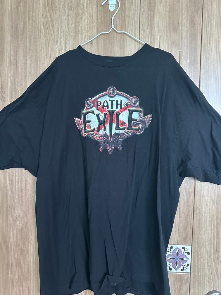 검은 배경의 티셔츠에, 가슴 부분에 게임 『Path of Exile』의 로고가 인쇄되어 있다.