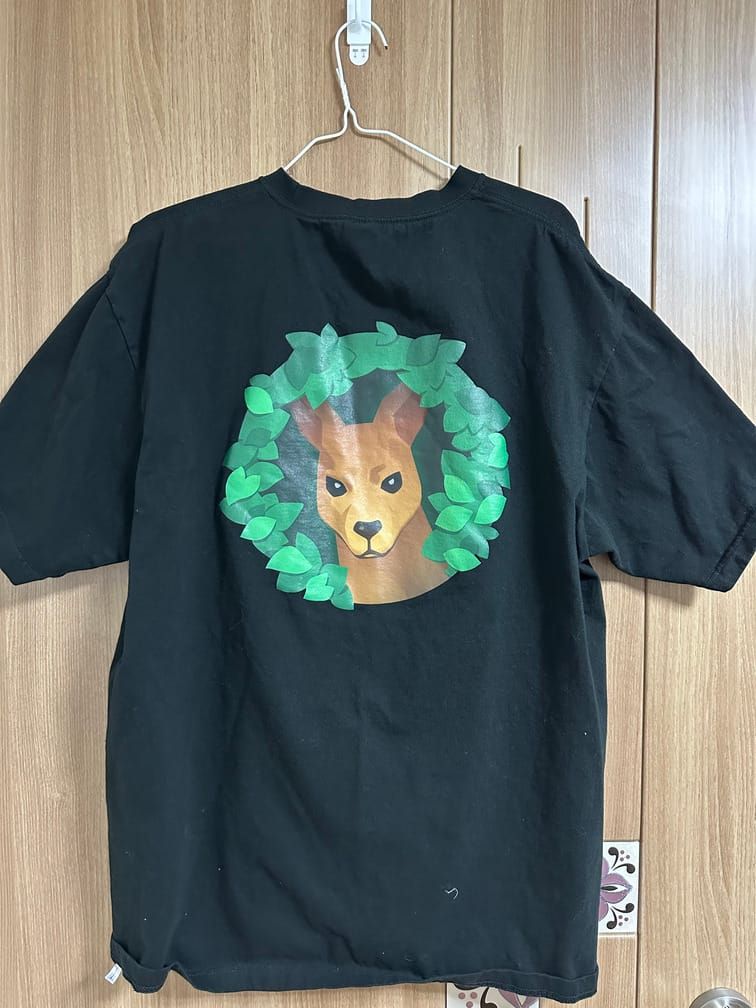 검은 티셔츠의 등 부분에, 동그란 풀 테두리 사이로 캥거루가 이 쪽을 째려보고 있는 도안.