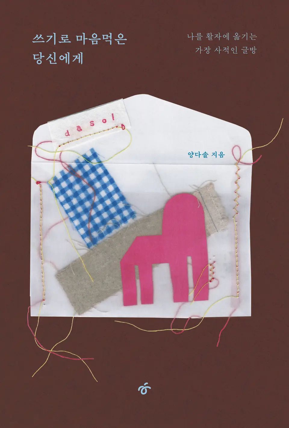 책 『쓰기로 마음먹은 당신에게』의 표지. 갈색 배경에 흰 천과 실로 바느질된 편지봉투 모양 안에 천조각으로 모양이 꾸며져 있는 모습.