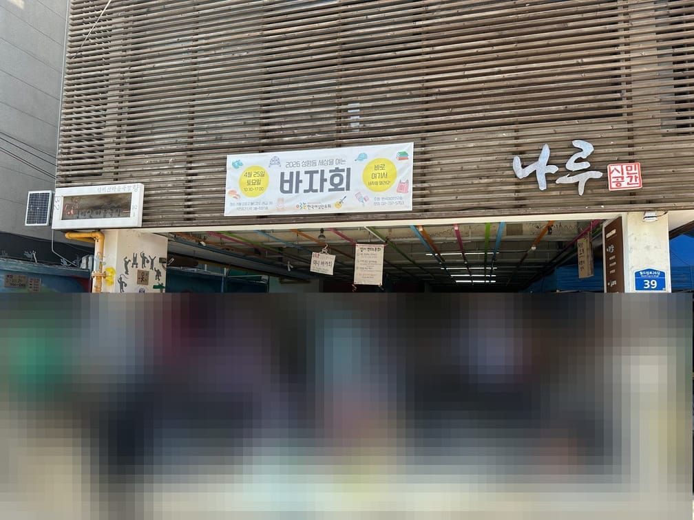 건물에 『시민공간 나루』라는 이름과 바자회의 플래카드가 붙어 있고, 아래에는 사ᄅᆞᇁ들이 바자회에 온 물건을 보고 있는 사진.