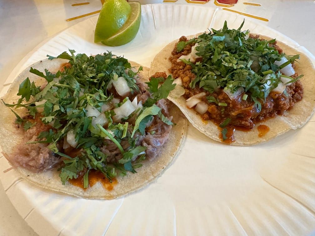 일회용 그릇 위에 두 개의 따꼬와 라임 두 조각이 올라와 있다.