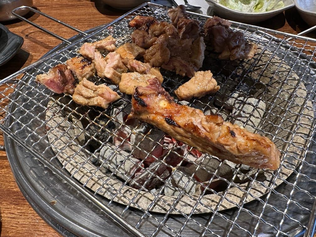 숯불 위 석쇠에 돼지갈비가 구워지고 있는 사진