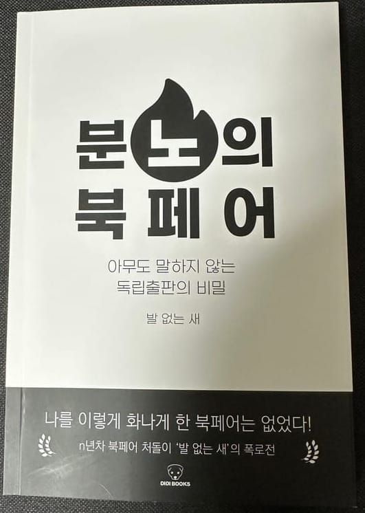 책 『분노의 북페어』의 표지. 흑백의 간단한 디자인에 제목 중 가운데 위에 있는 '노'자만 불꽃 모양으로 색이 반전되어 있다.