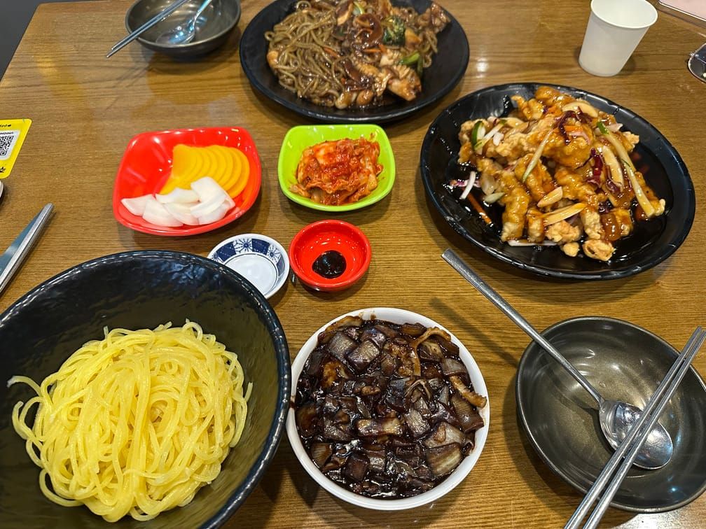 그릇에 차려져있는 중식면, 간짜장, 탕수육, 쟁반짜장.