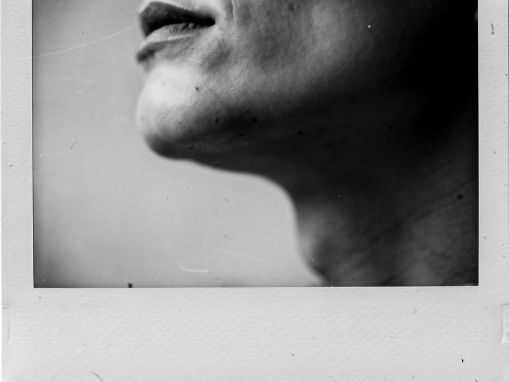 Black and white photo of a person's defined cheekbone and jaw