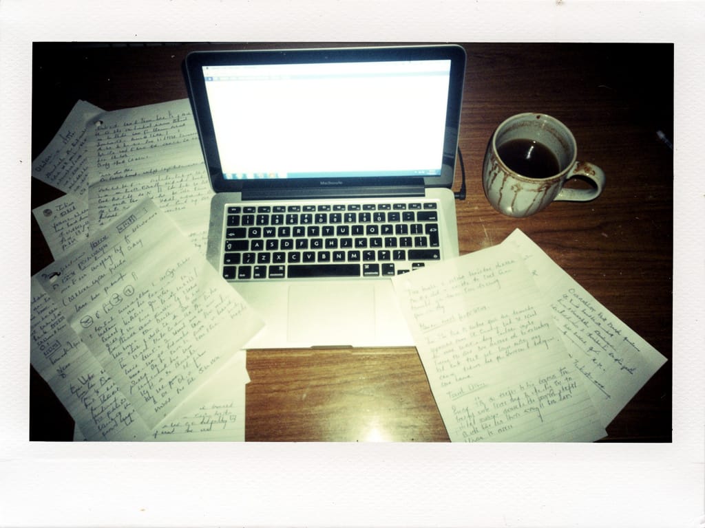 Overworked desk setup with blue screen light and cold coffee