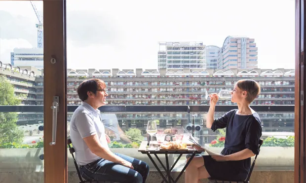 Comfortable: estate residents dine out on their balcony. Photograph: Anton Rodriguez