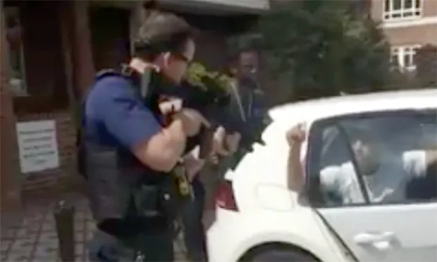 Armed police captured on video pointing assault rifles at two men holding their hands up