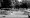 Black and white photo of children playing in large paddling pool.