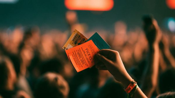 image of rock concert tickets in a fan's hand