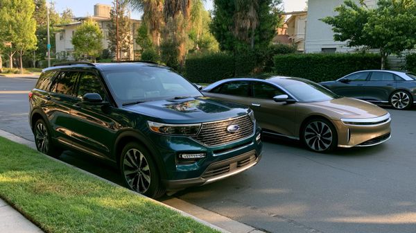 image shows a ford and lucid parked together
