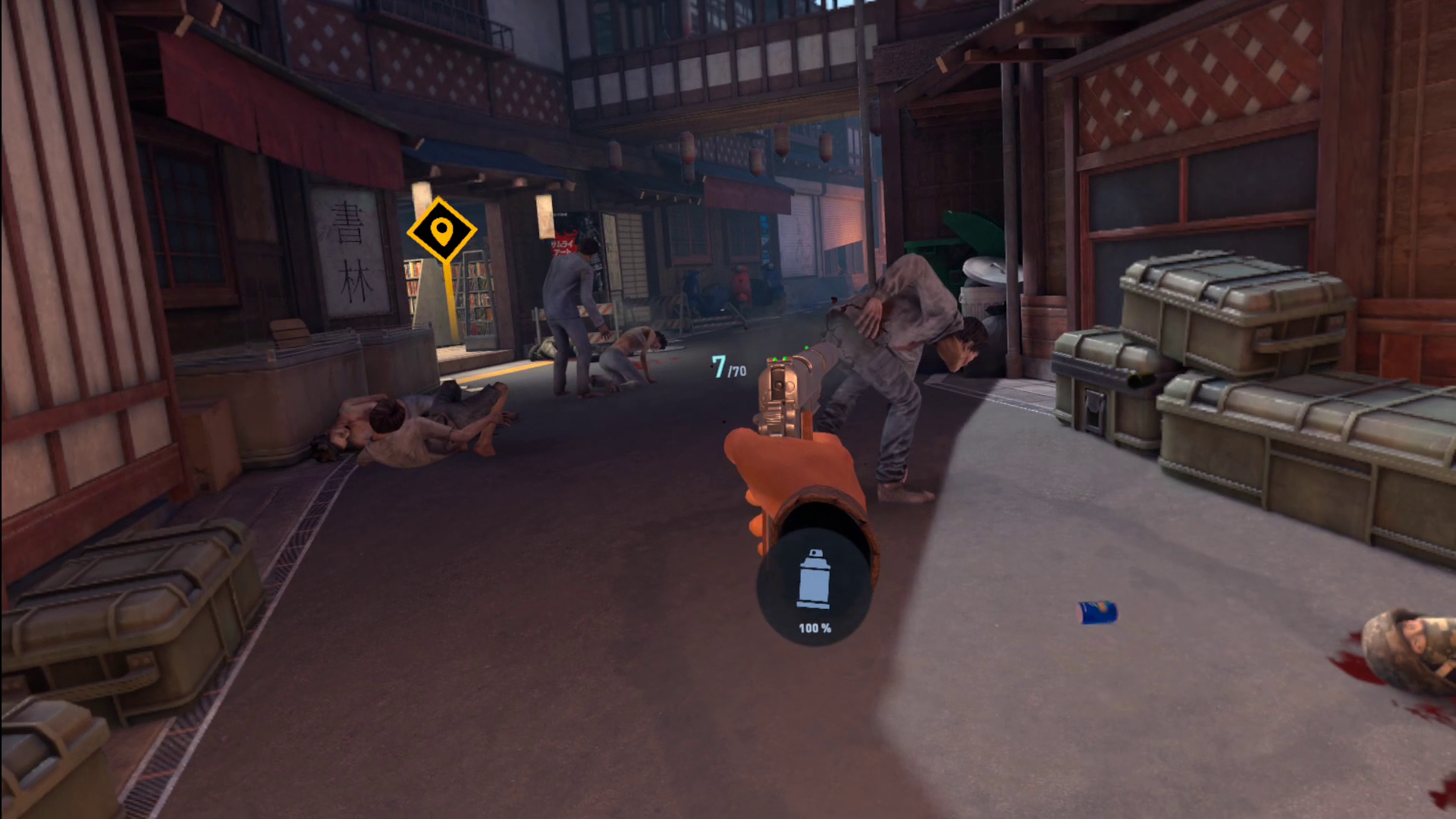 The player, wielding a silenced pistol, shoots at zombies to remain undetected while navigating an alleyway. There is an icon by their wrist indicating a full healthkit spray can, and in the background, there's a yellow marker indicating where to traverse next.