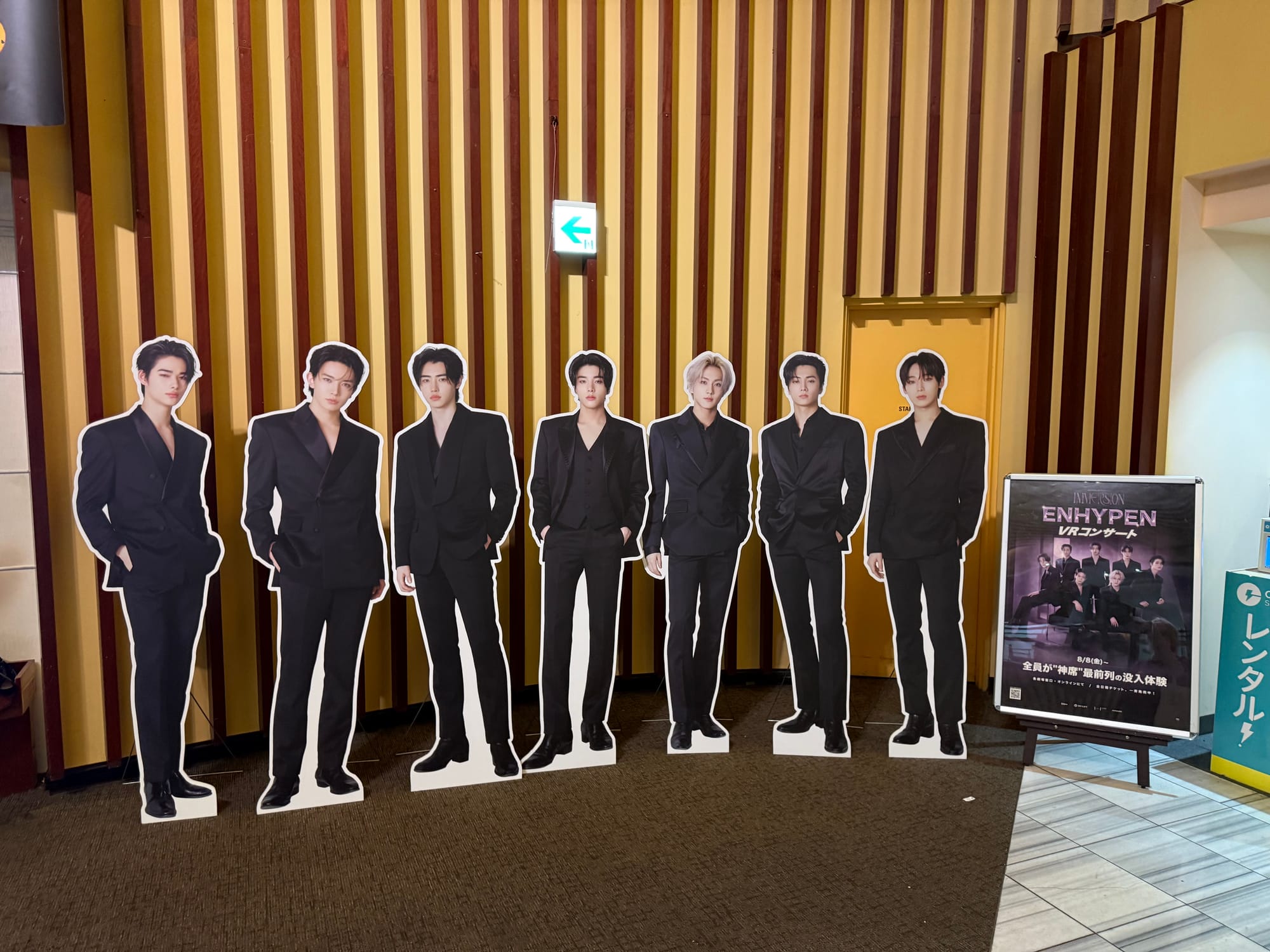 Cardboard cutouts for each member of ENHYPEN in a cinema room