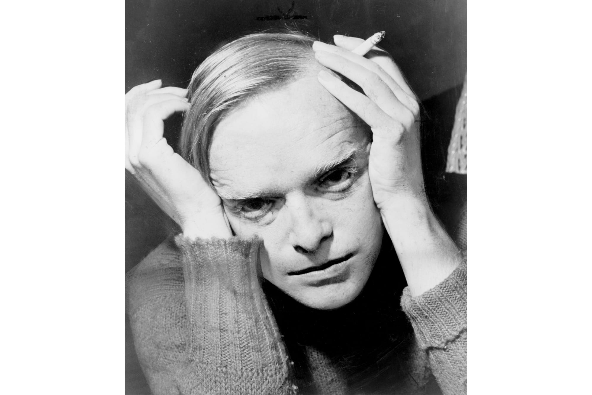 Black and white portrait of Truman Capote holding a cigarette