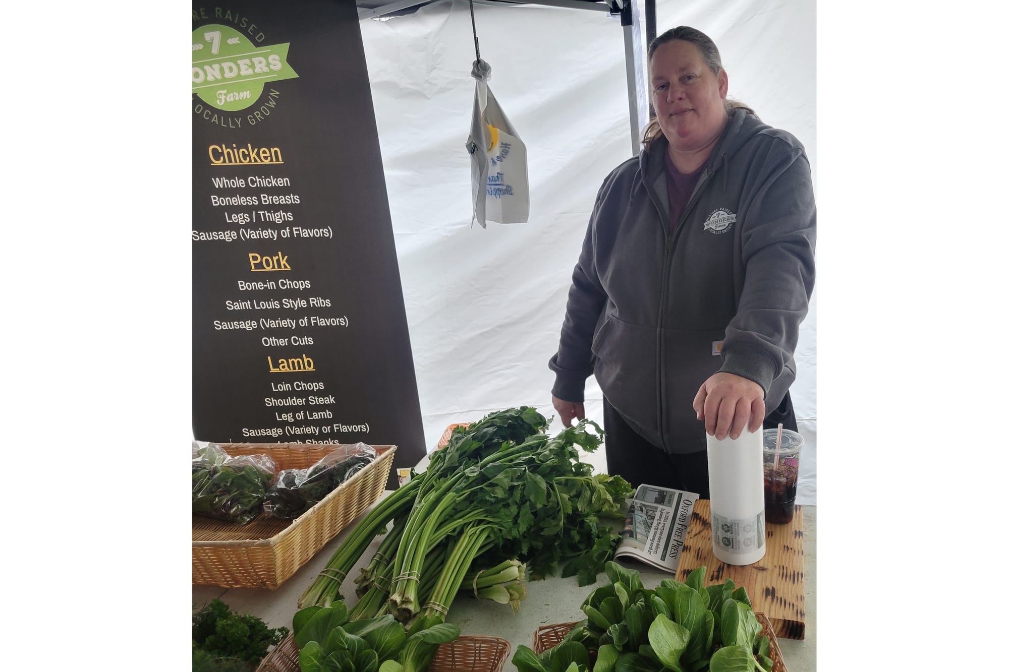 Jennifer Bayne stands behind a table with greens