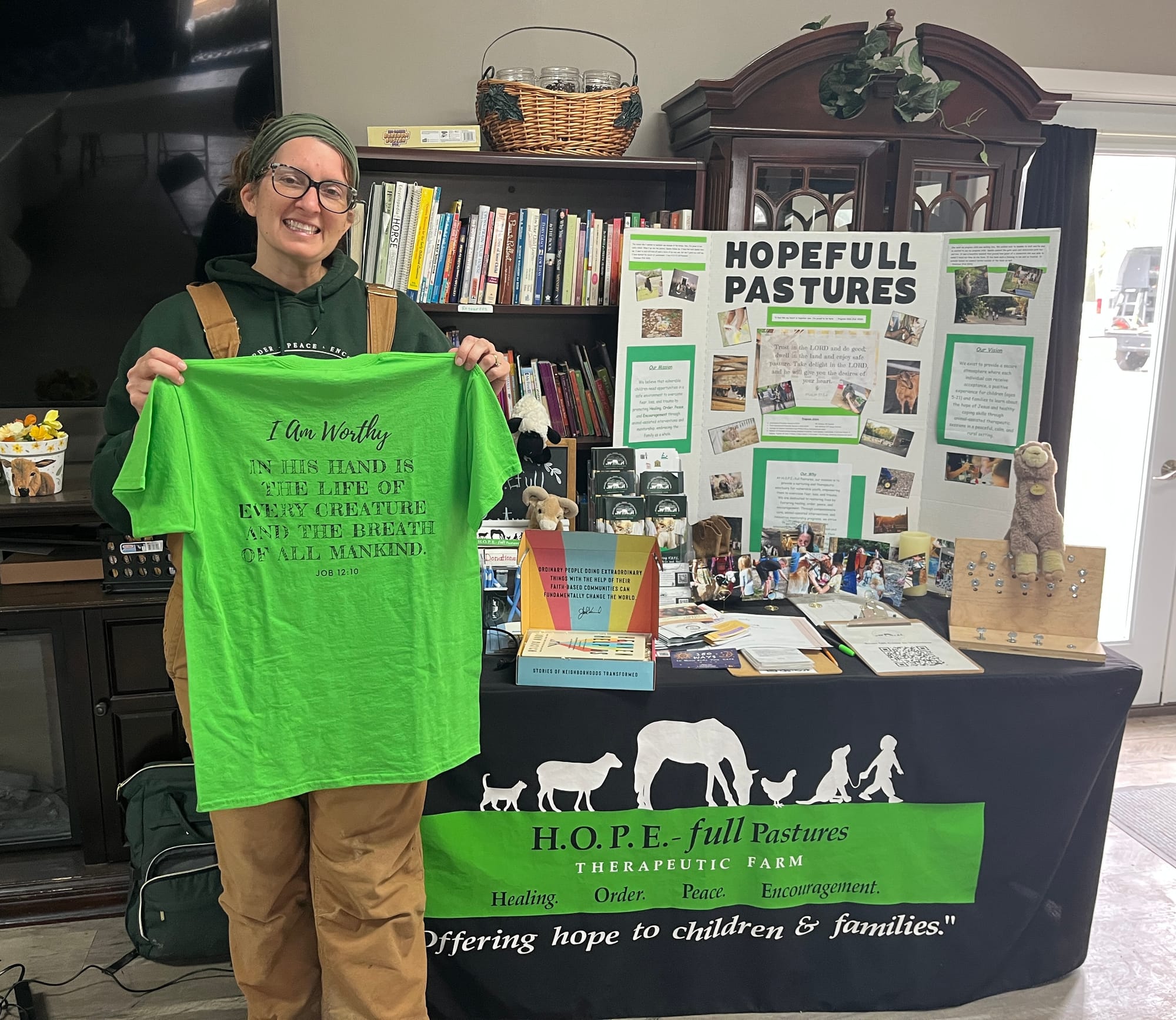Christa Carrero poses in front of a table with HOPE-full Pastures information