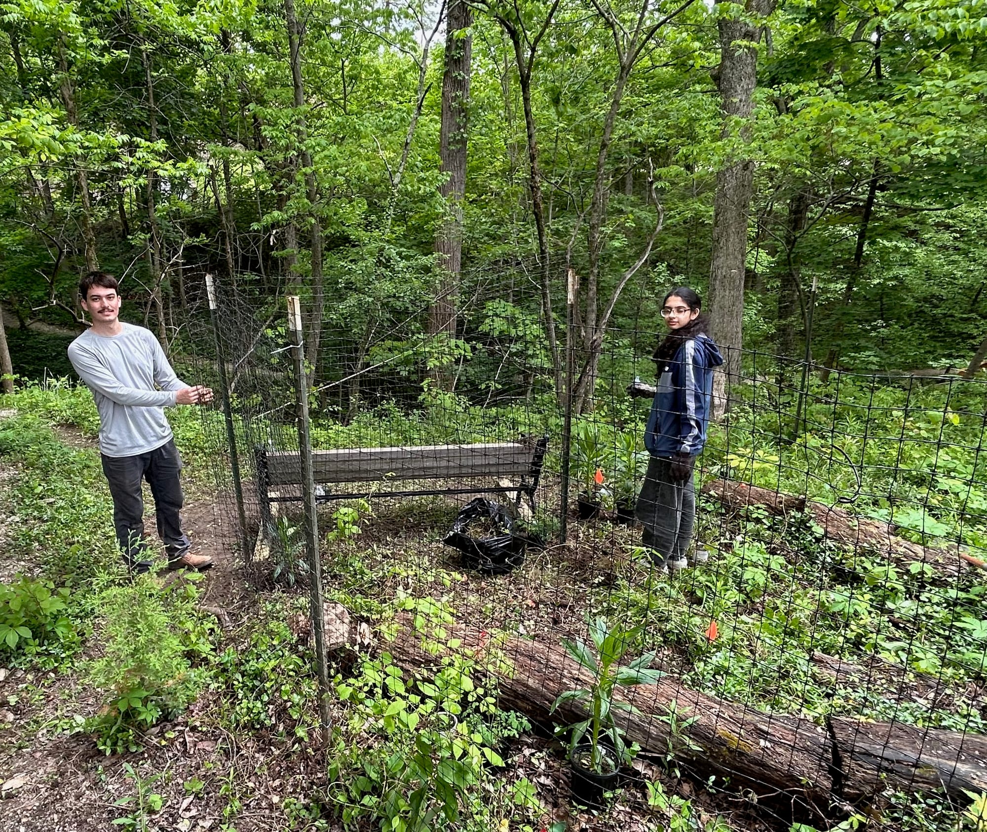 nviroCorps members Evan Usher (left) and Areej Mirza (right) help remove invasive plants