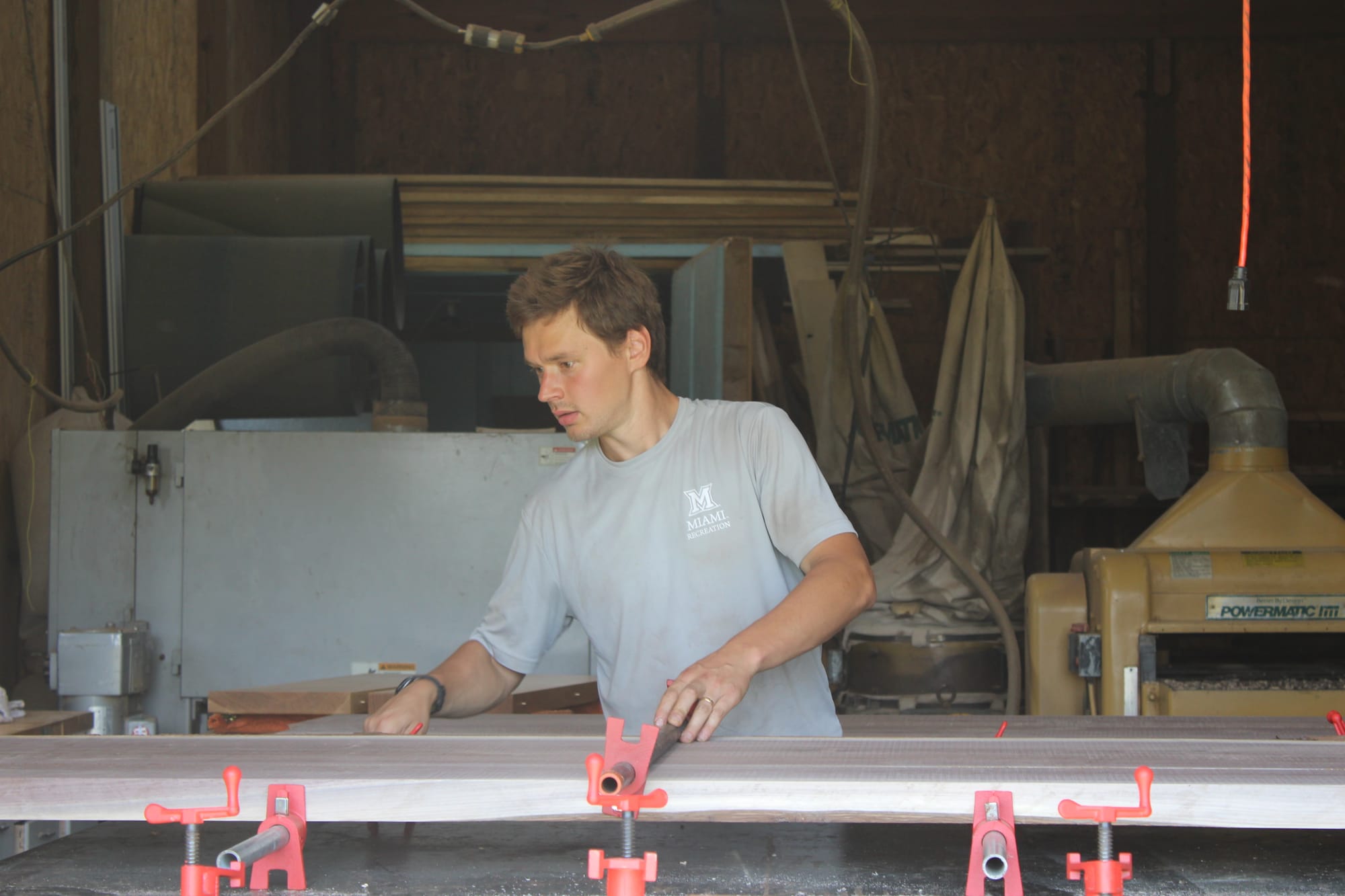 Vilppu Anttila removes the clamps from a wooden table.