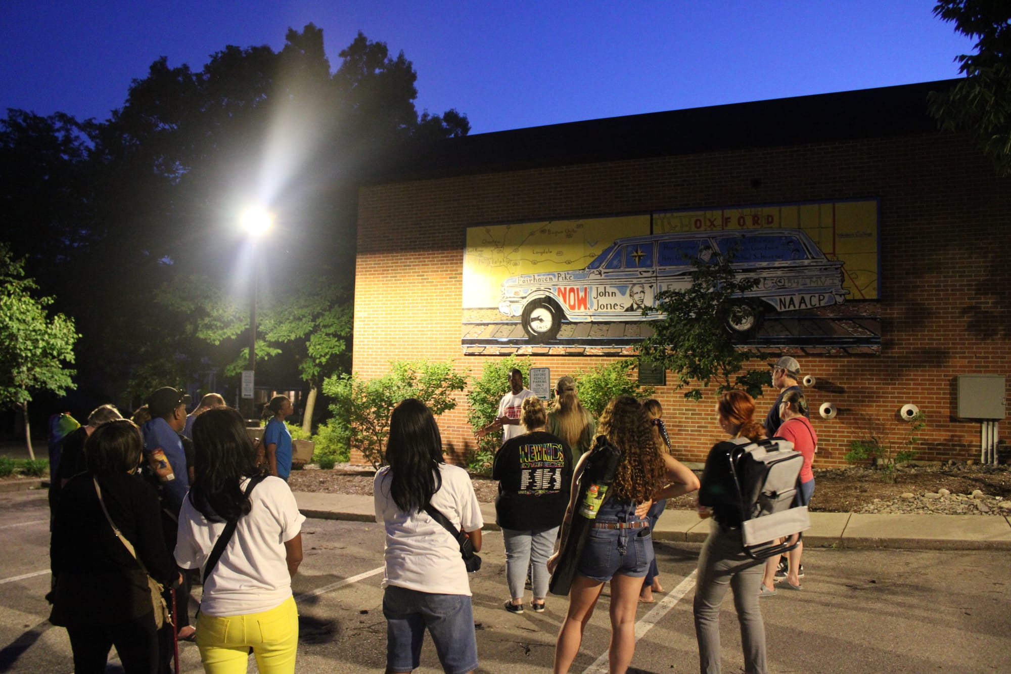 Brian Revere talks to a crowd in front of the “Changemakers of Ohio” mural at the Municipal Building