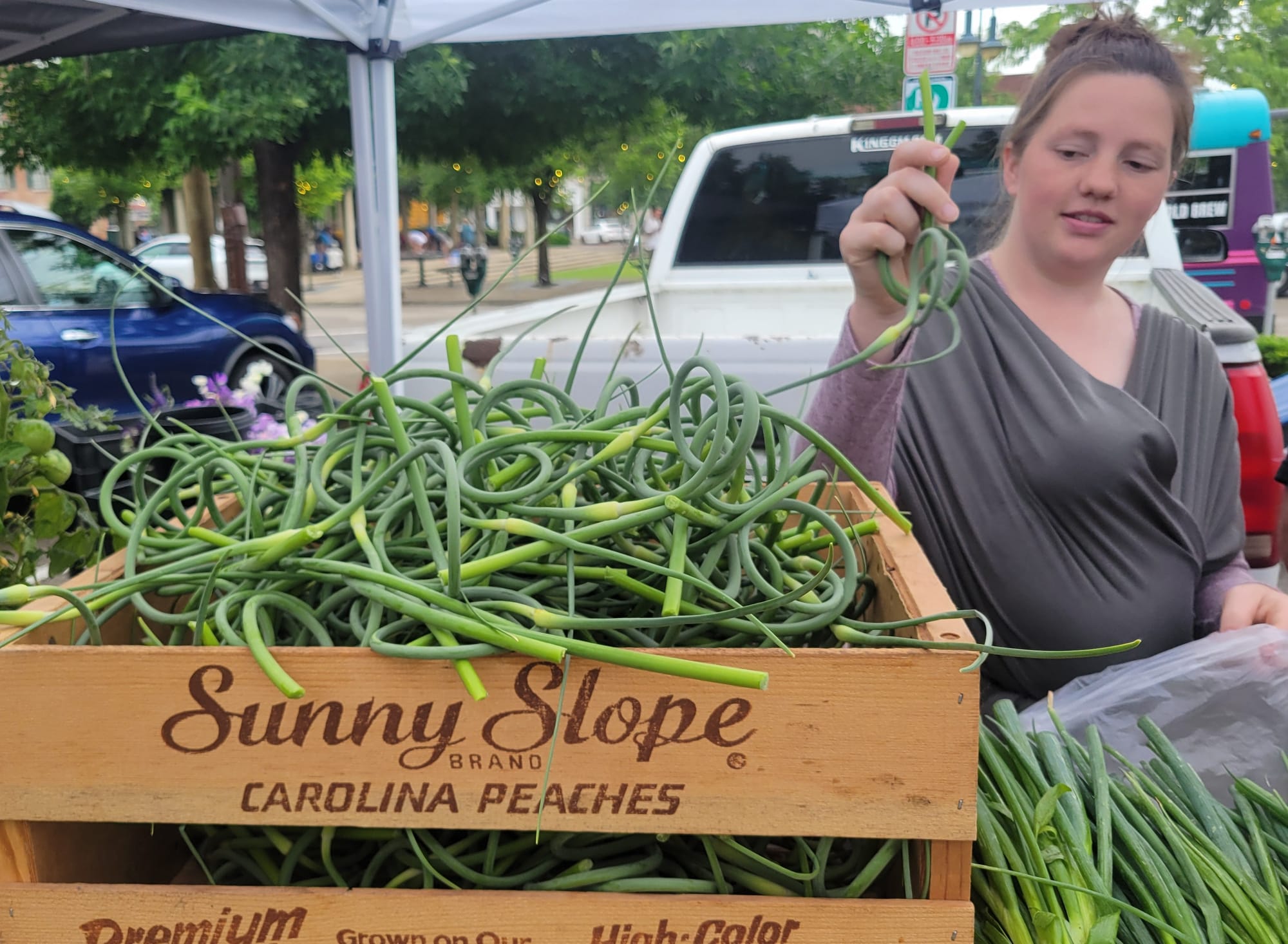A woman pulls a scape from a crate of them.