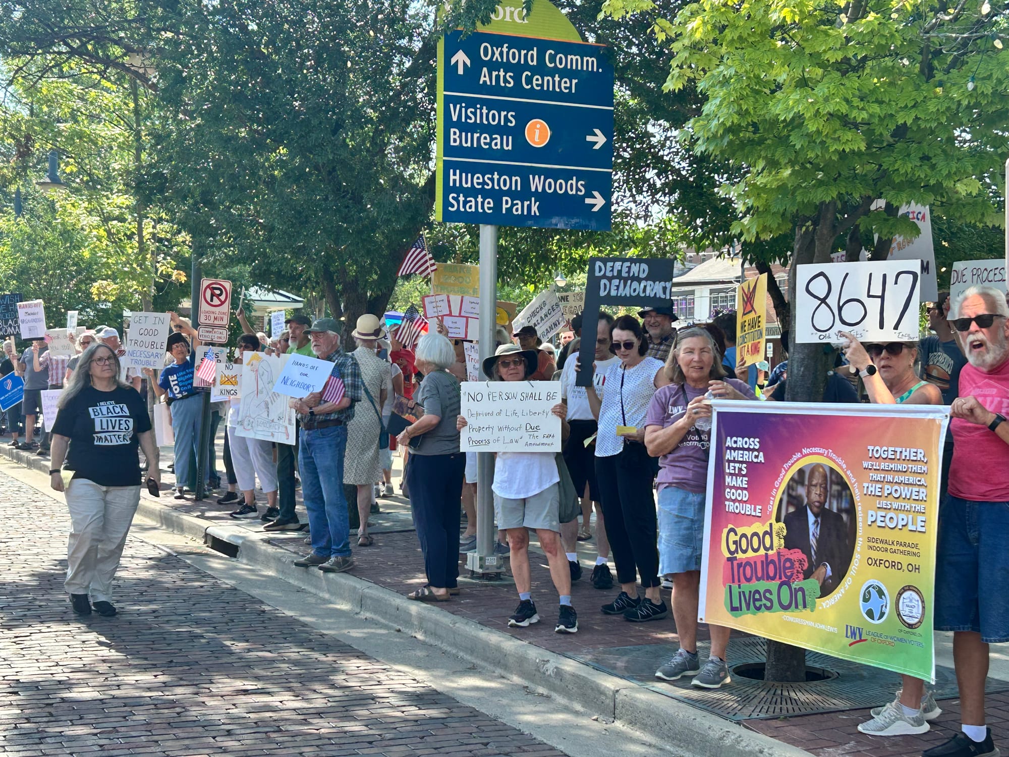 Protesters carry signs and participate in chants at the “Good Trouble Lives On” protest