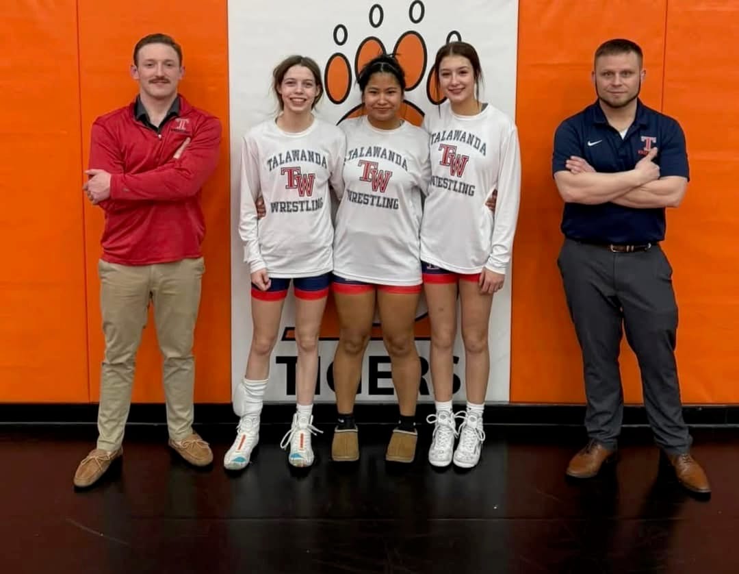 Talawanda wrestling coaches stand beside three members of the team