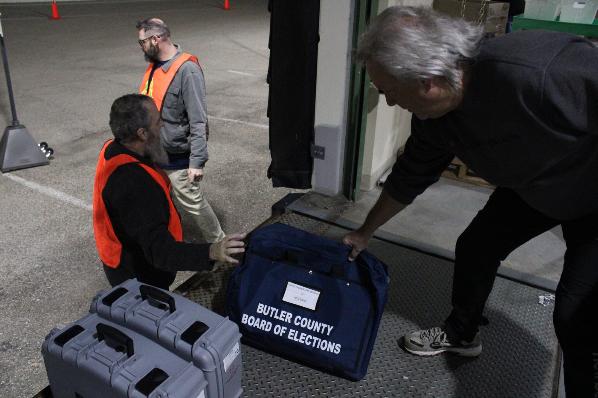 A volunteer passed a bag reading "Butler County Board of Elections" off to another volunteer.