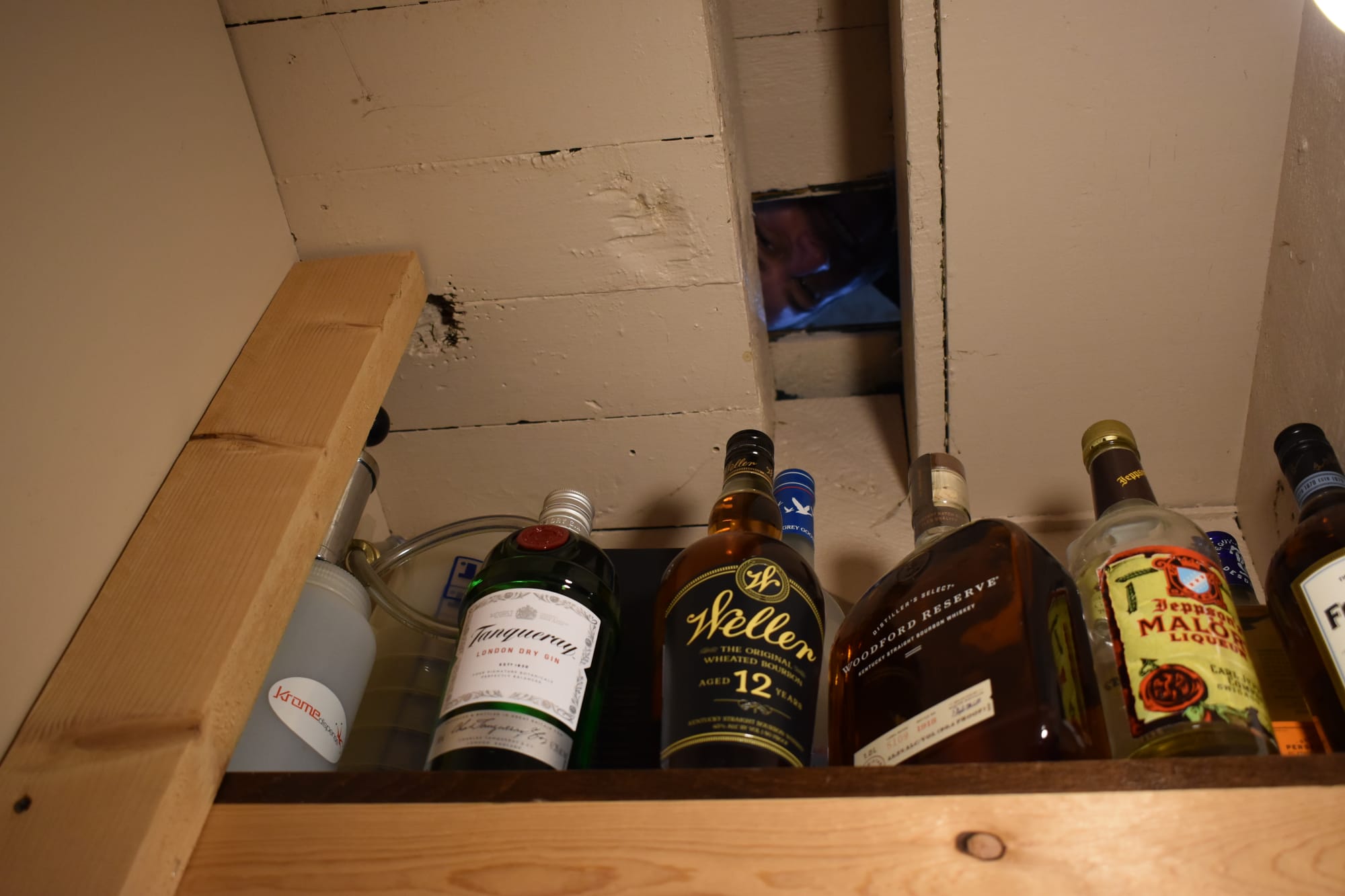 Evan Cusmano, owner of The Hitching Post Saloon, peeks through a peep hole on the second floor down to the first,