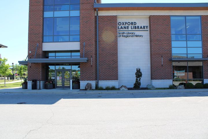 Two story brick and window building labeled "Oxford Lane Library"