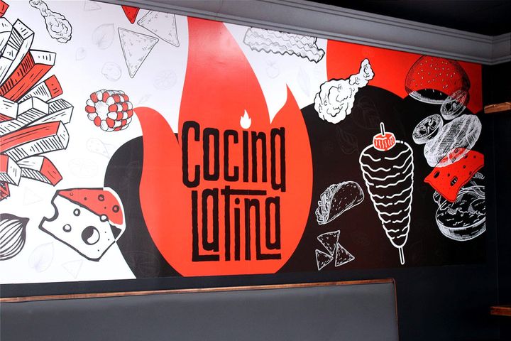 Cocina Latina's wall that has a mural of different food on it in orange, black and white.
