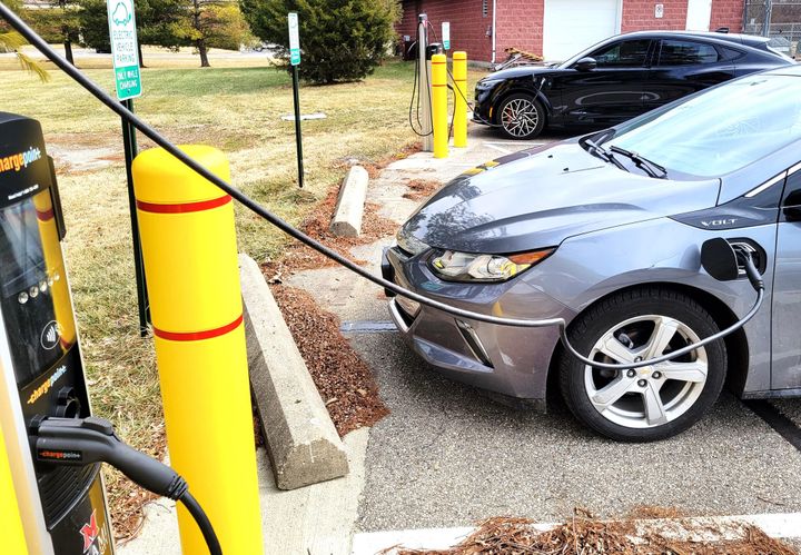 An electric vehicle plugged into an outdoor charging station