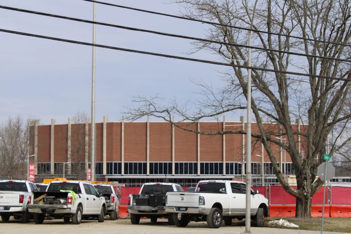 Several pickup trucks parked in front of Millett Hall