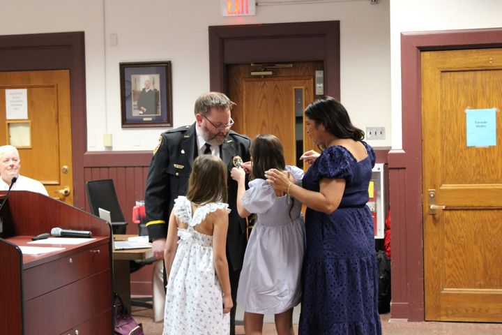 Adam Price's wife and daughters pin his new badge on his OPD uniform