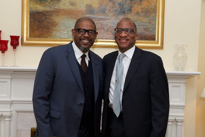 Wil Haygood stands in a suit with another man