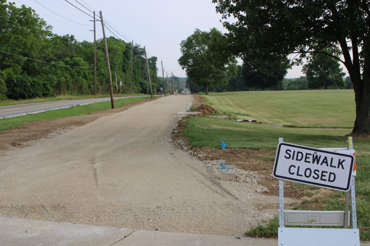 An unpaved path with a "sidewalk closed" sign outside Talawanda Middle School