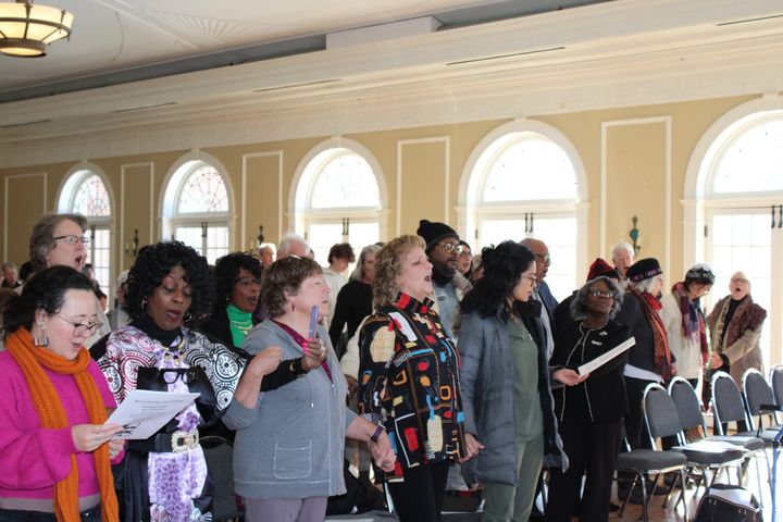 A group of people sings in the Oxford Community Arts Center