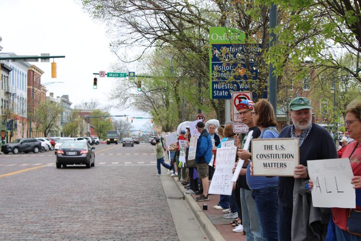 Protestors holding signs line High Street