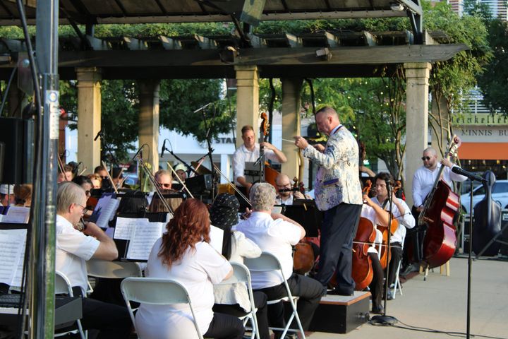 A man conducts a concert at a performance in Uptown