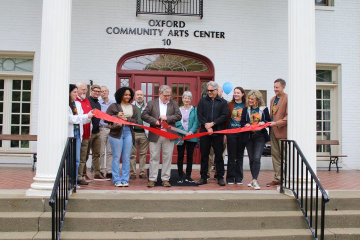 Mike Smith cuts a ribbon in front of the Oxford Community Arts Center. 