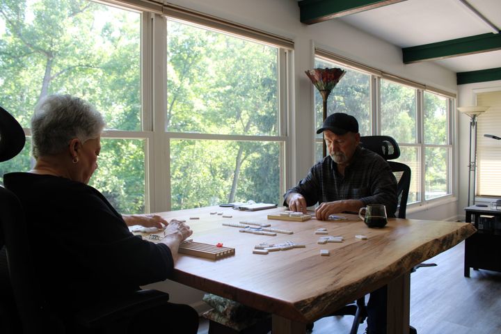 Candy and Lance Miller play dominoes on their custom-made table.