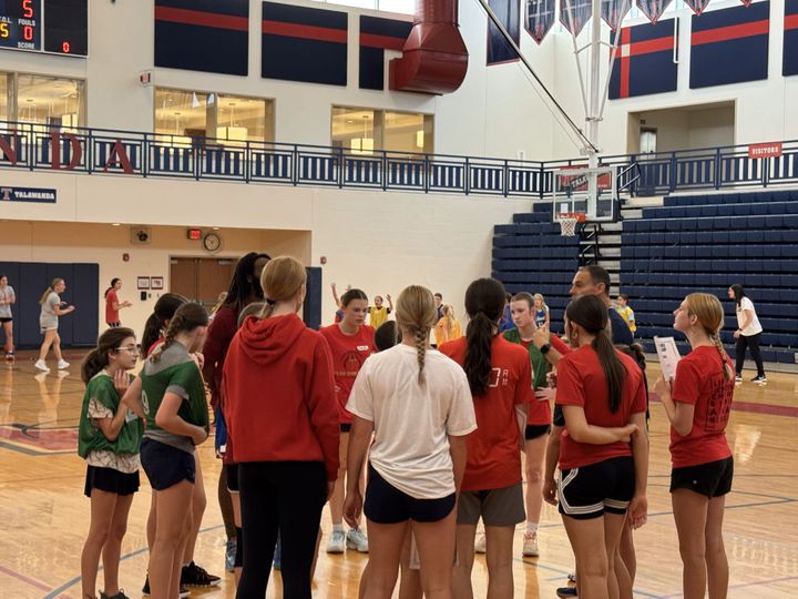 A group of older kids participating in Talawanda's girls' basketball camp discuss their scrimmage