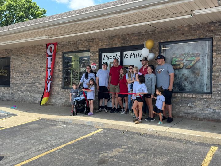 The Baker family celebrates the opening of Puzzle & Putt with a ribbon cutting ceremony