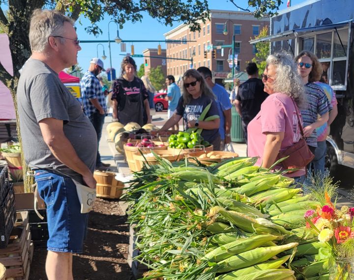 A booth at the Oxford Farmers Market sells sweet corn.