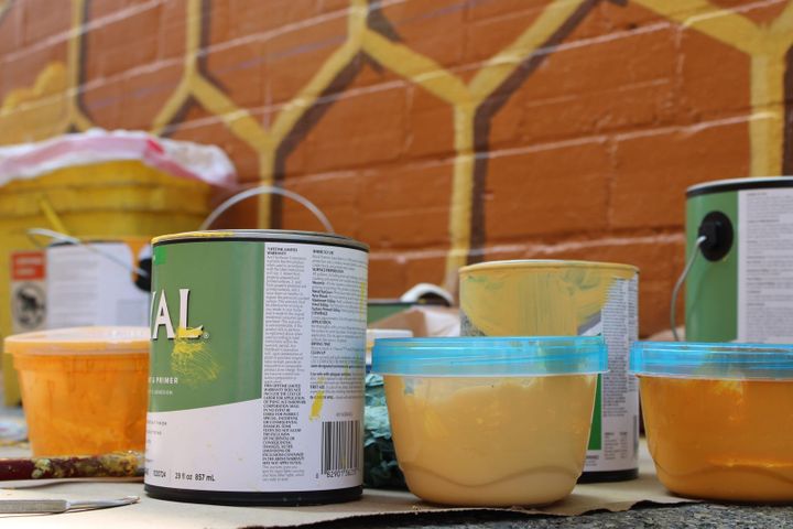 Buckets of paint set in front of the Oxford Hive Mural