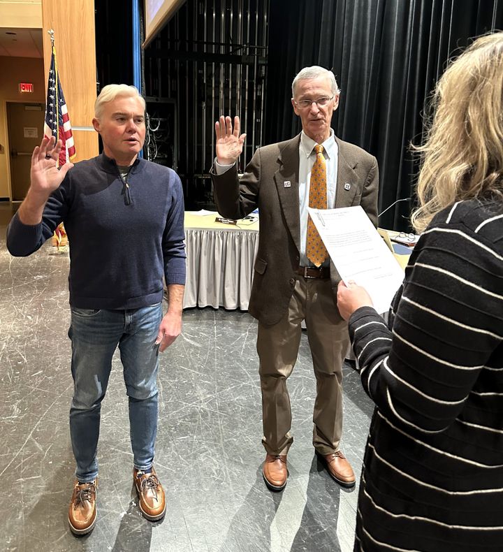 Talawanda School District Board of Education members Pat Meade and Matt Wyatt raise their hands