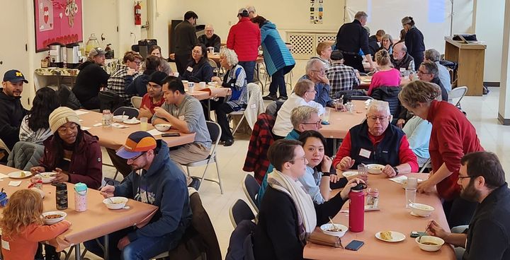 People gather at tables and eat chili