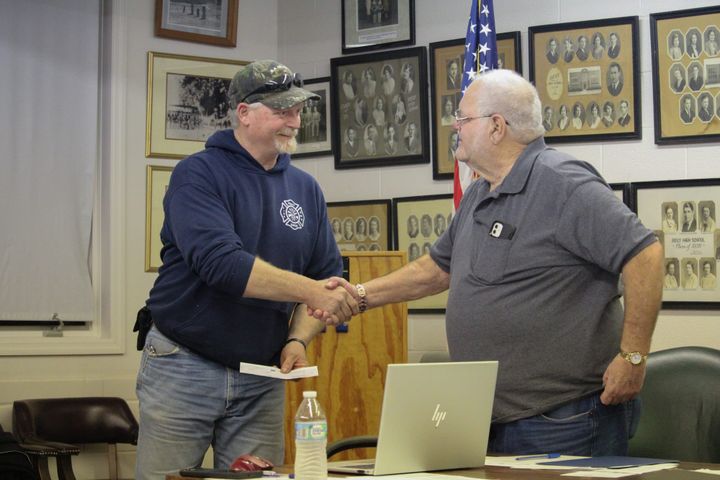 Reily Township Trustee Dennis Conrad, right, shakes Reily Volunteer Fire Department Chief Clayton Lightfield’s hand