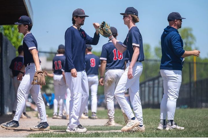 JV Head Coach Evan Kennel giving a glove to pitcher Jack Segall after a 2025 game